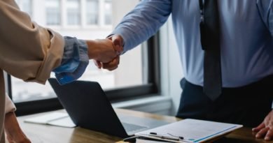 crop colleagues shaking hands in office